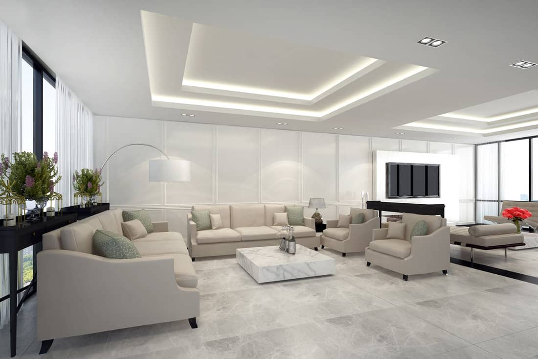 A white dropped ceiling with backlighting inside a modern living room