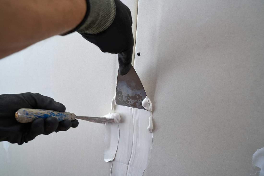 Applying joint compound on laminated plasterboard