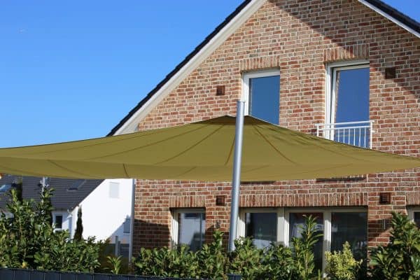 Back yard with large shadesail. - How To Attach A Shade Sail To A House