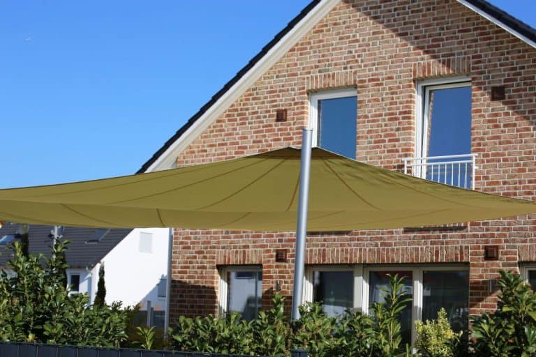 Back yard with large shadesail. - How To Attach A Shade Sail To A House