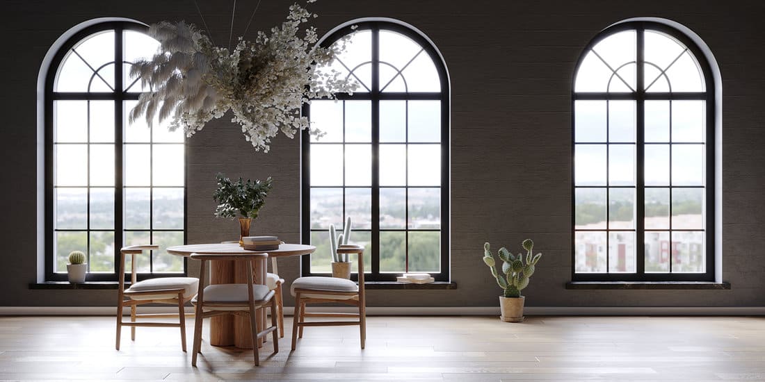 Black interior with large arch windows and hanging flower cloud over the round table