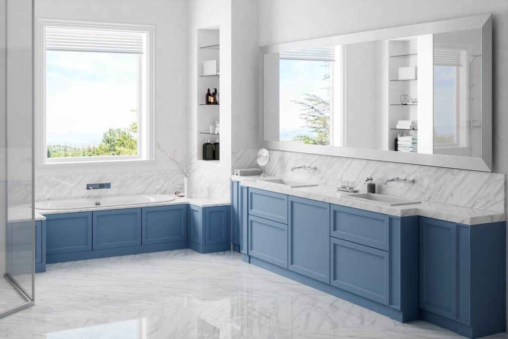Blue colored cabinets inside a white modern bathroom