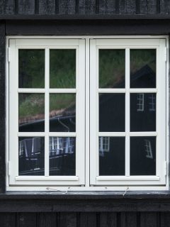 Colonial style casement window of white painted wood in a black tongue and groove plank facade, What Are The Different Parts Of A Casement Window?