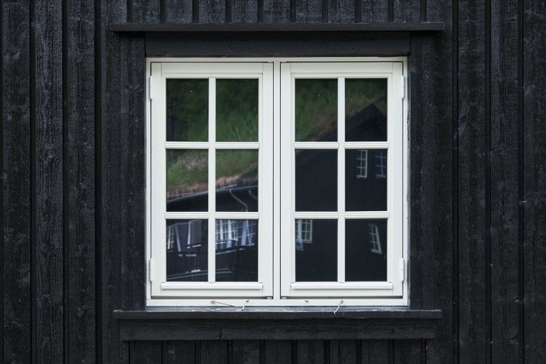 Colonial style casement window of white painted wood in a black tongue and groove plank facade, What Are The Different Parts Of A Casement Window?