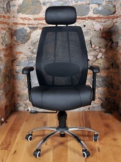 Comfortable and stylishly designed black office chair in front of a wall