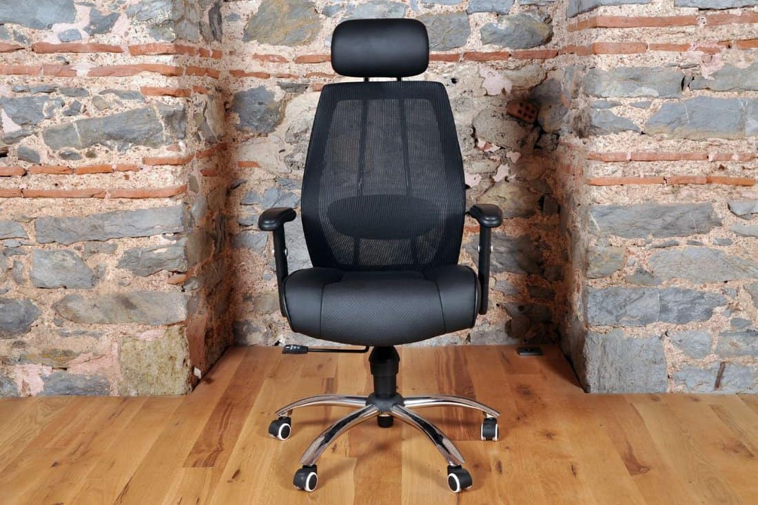 Comfortable and stylishly designed black office chair in front of a wall 