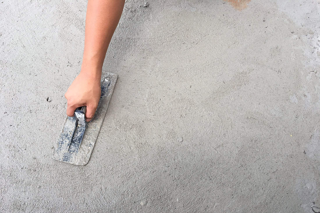Construction workers using hands to cut the mortar concrete floor