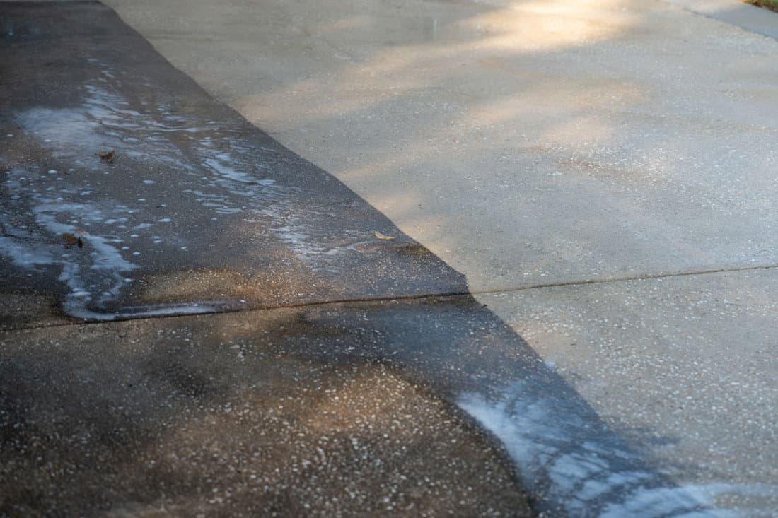 Dirty concrete and cleaned concrete by a pressure washer