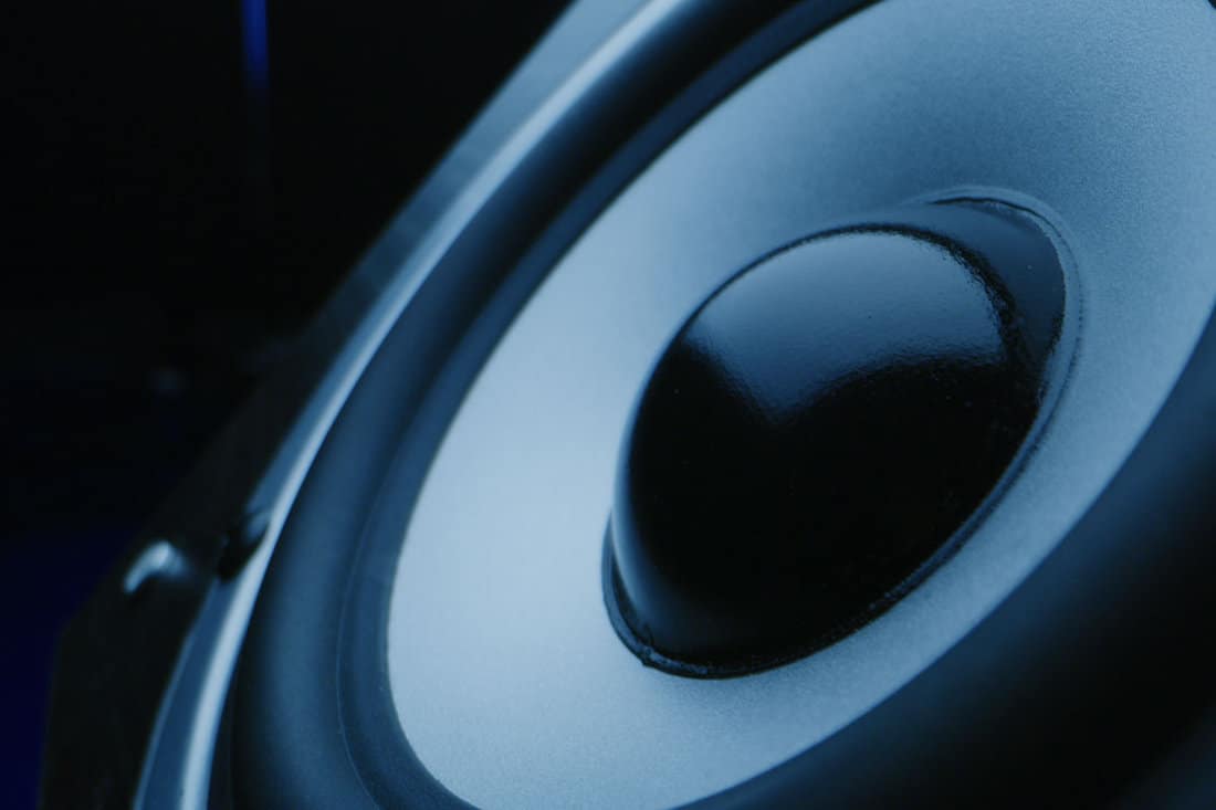 Extreme close-up of a subwoofer pulsating produced static noise through it