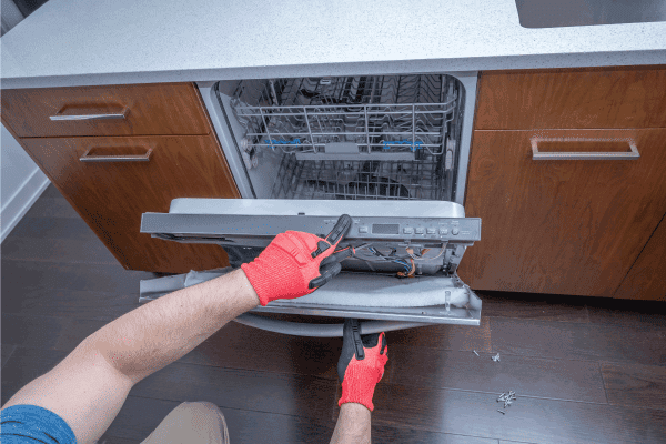Hands taking apart and repairing a dishwasher inside of a home, My Dishwasher Float Is Not Operating Properly - Why? How To Fix?