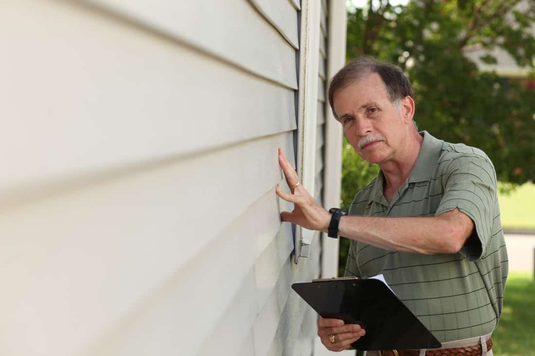 House contractor checking the house siding if its properly laid