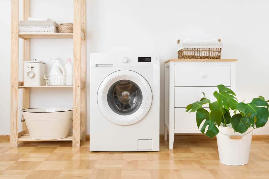 Interior of simple home laundry room with modern washing machine