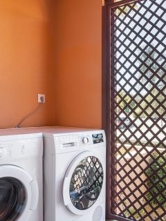 A laundry room with a washing machine and dryer and a boiler on top, How To Hide A Water Heater In The Laundry Room [9 Ideas To Inspire You!]