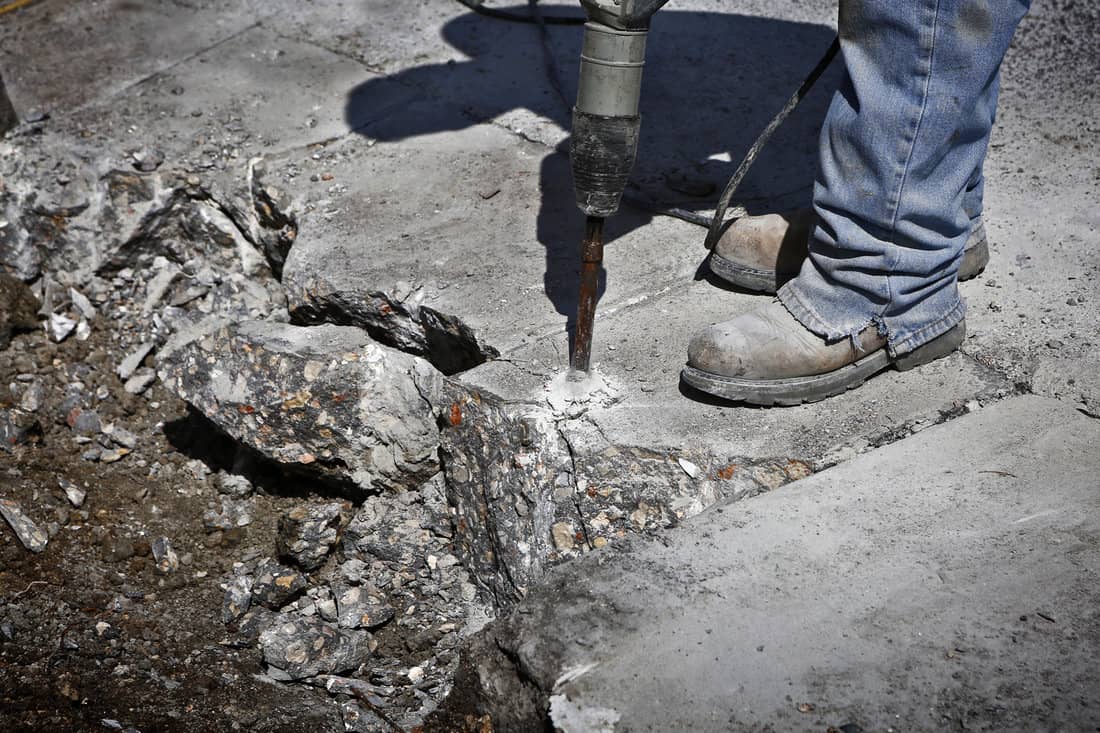 Man drilling cement concrete road 