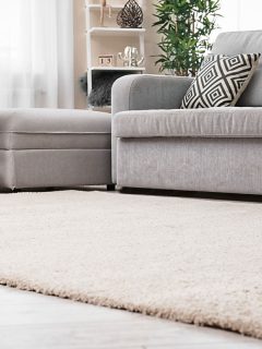Modern living room interior with cozy sofa and soft carpet, What Size Rug To Layer Over A 9X12 Rug?