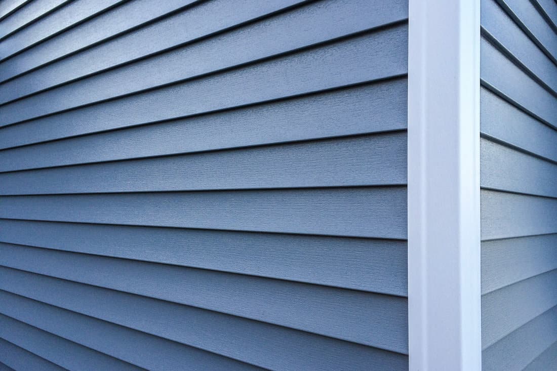Photography of new, blue vinyl siding on a home. 
