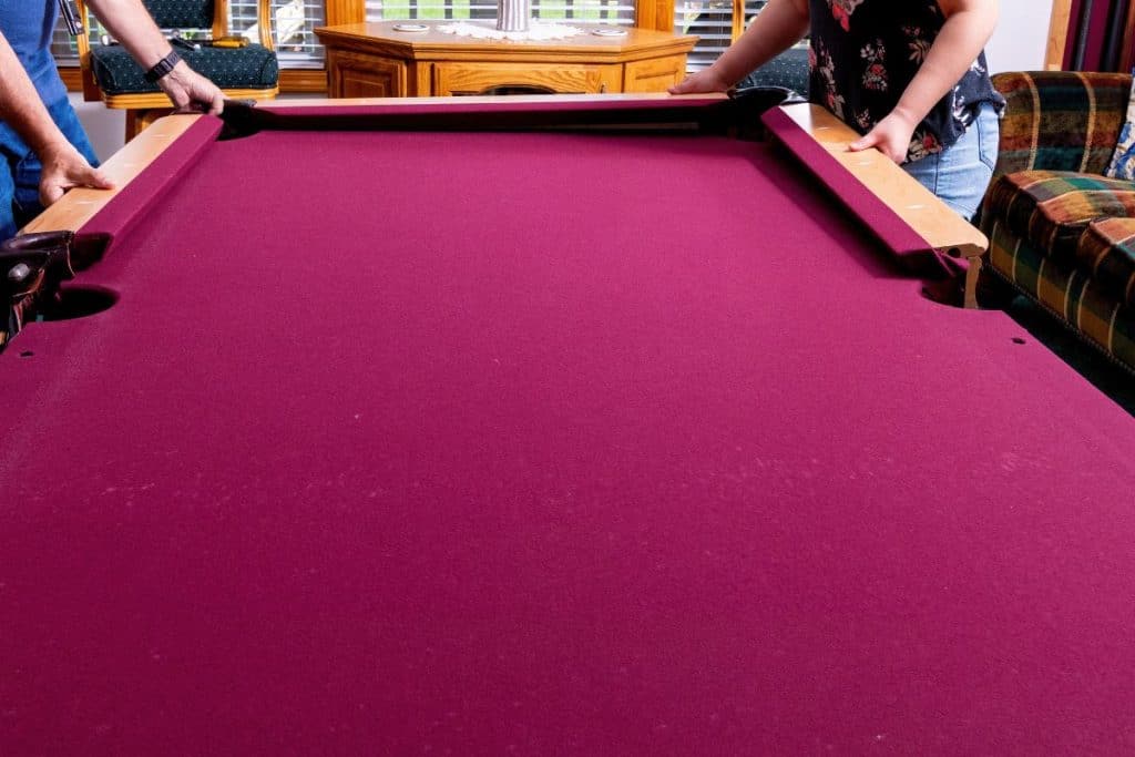 Red felt pool table is in the process of disassembly
