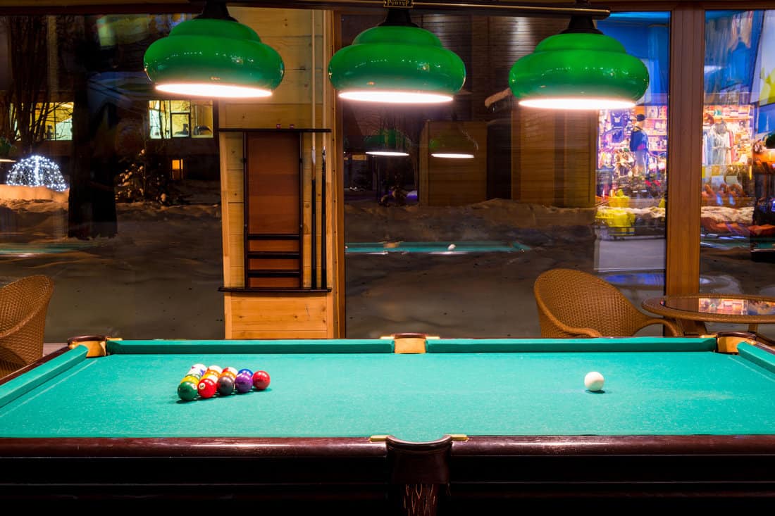 Sports game of billiards on a green cloth. Multi-colored billiard balls with numbers on a pool table 