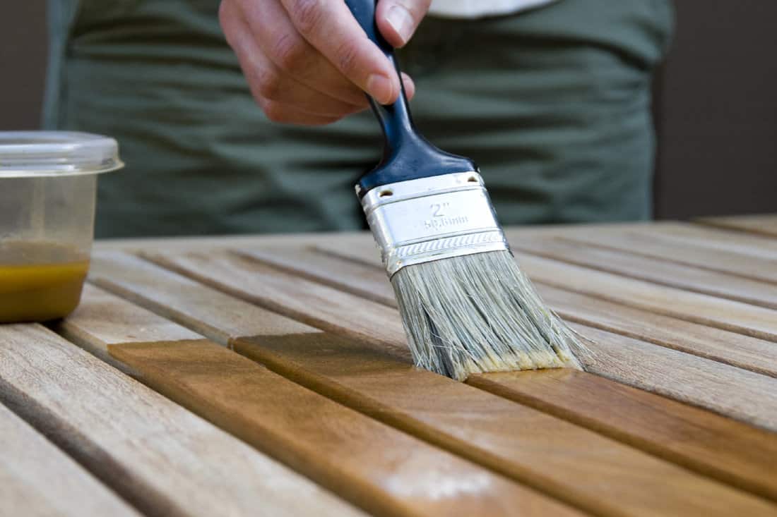 Woman applying stain to wood