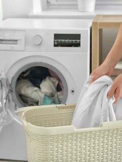 Woman doing laundry at home, Can You Wash Blankets With Clothes?