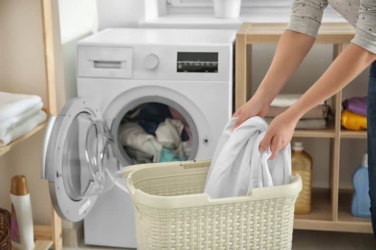 Woman doing laundry at home, Can You Wash Blankets With Clothes?