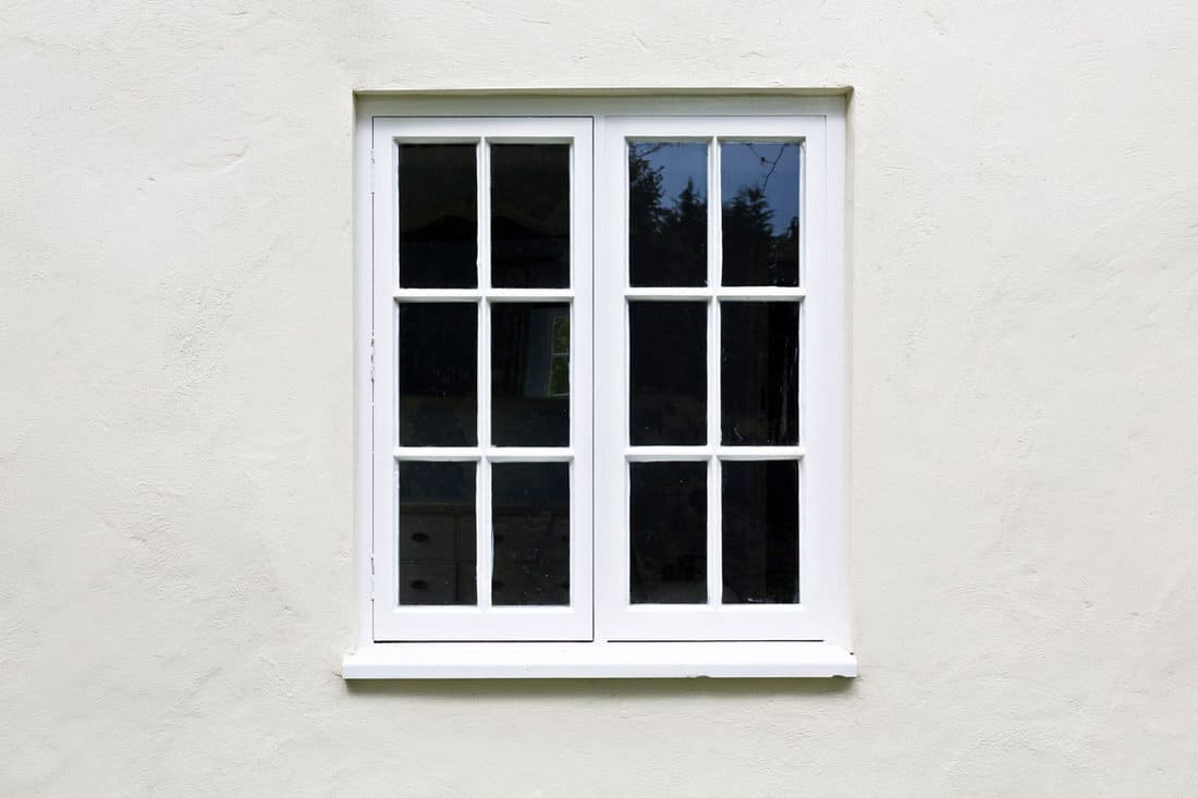 Wooden windows and sill on a home exterior. Cottage windows