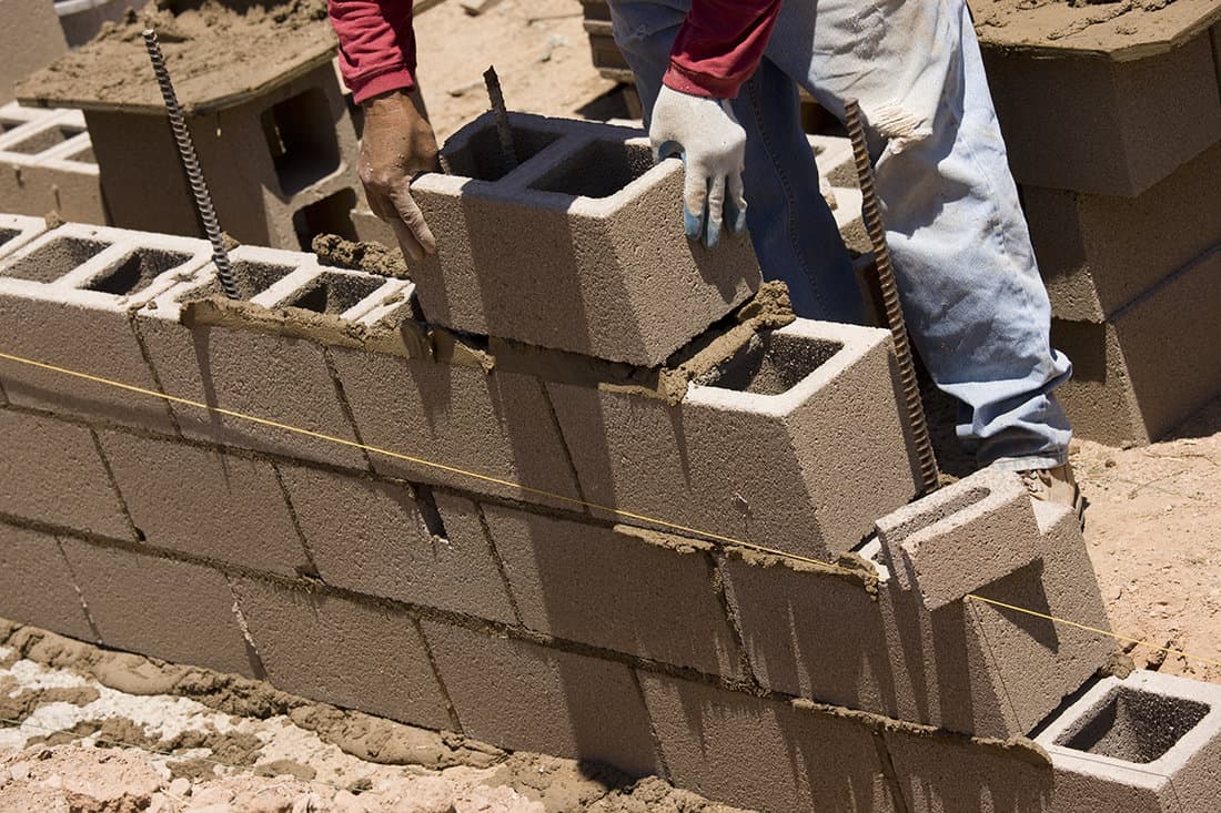 Worker building cinder block wall