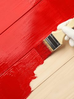 Worker in gloves painting wooden surface with red dye, top view. Space for text, Why Is Your Paint Not Sticking To Wood? [& What To Do About It?]