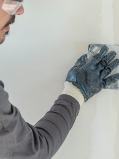 A worker sanding dry wall, Do You Need To Prime Spackle?