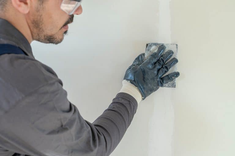 A worker sanding dry wall, Do You Need To Prime Spackle?