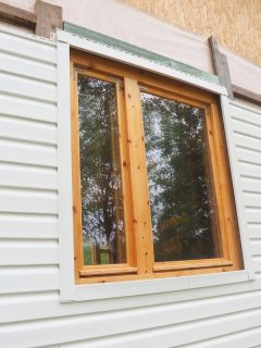 white siding of a frame house. - Should Windows Be Flush With Siding?