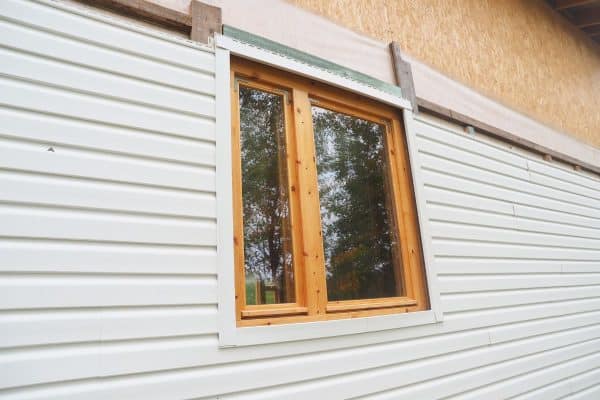 white siding of a frame house. - Should Windows Be Flush With Siding?