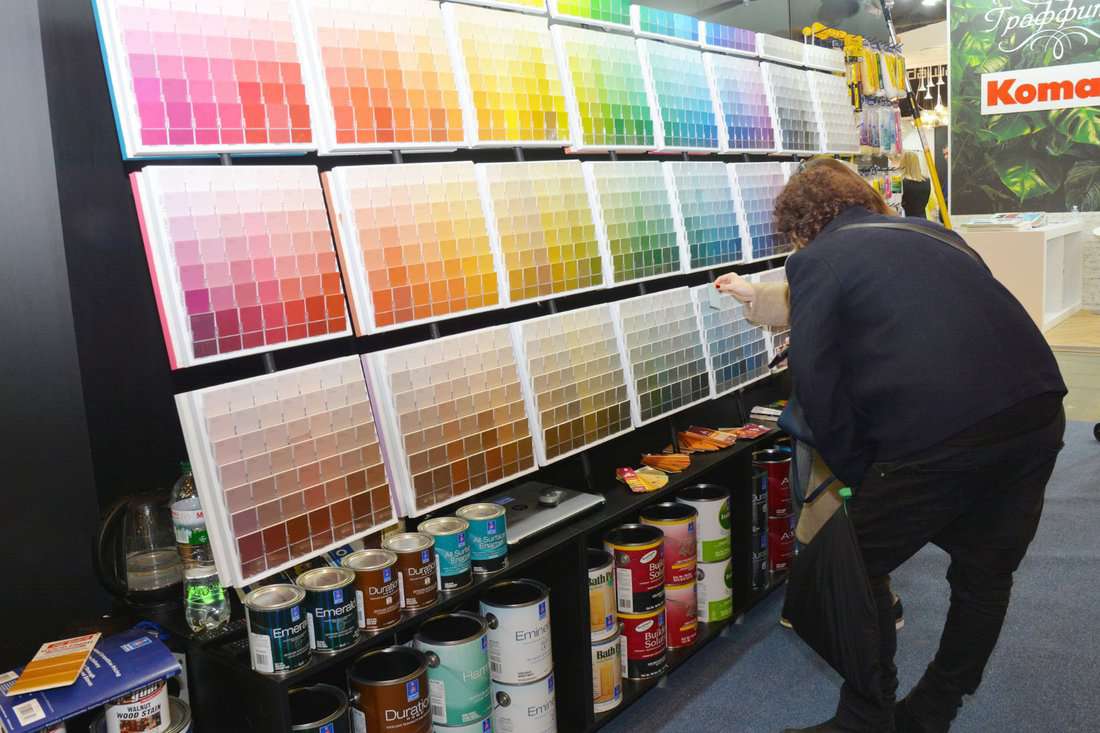 A customer is choosing the right interior paint color using the paint color palette in the store.