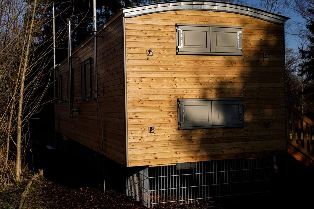 A large wooden construction trailer that is used as a tiny house