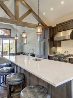 Amazing modern and rustic luxury kitchen with vaulted ceiling and wooden beams, long island with white quarts countertop and dark wood cabinets., Can You Paint Quartz Countertops?