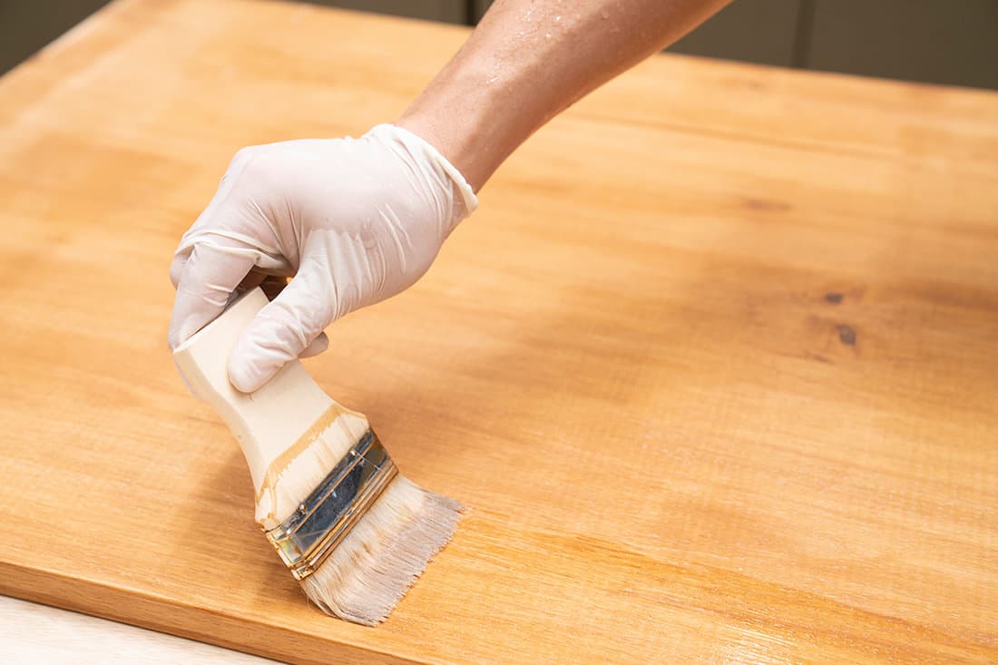 Applying protective varnish on a wooden furniture