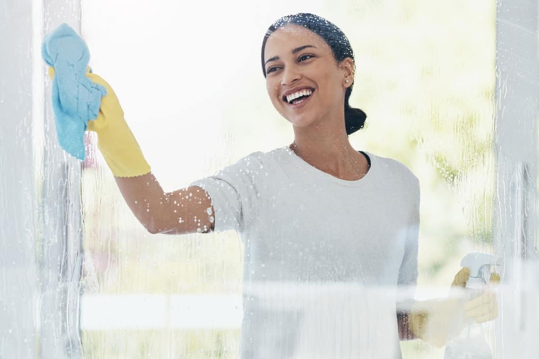 Woman cleaning glass and shower door