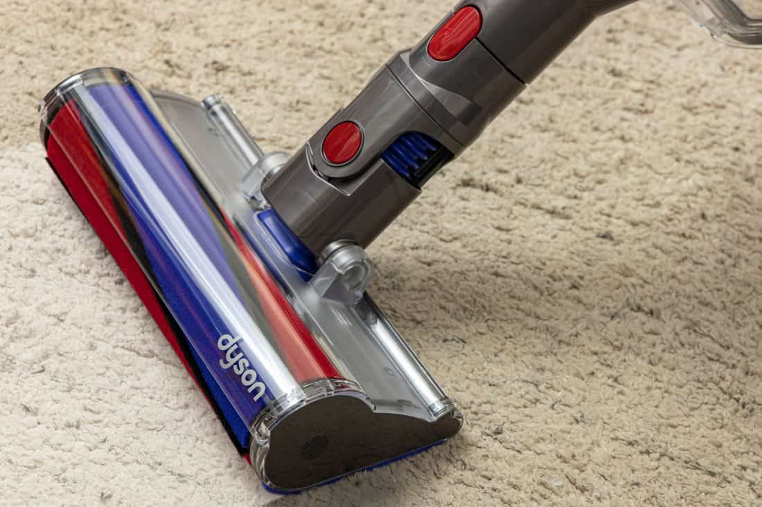 Close up of Dyson vacuum cleaner on a light carpet.