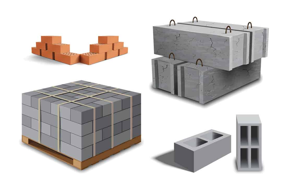 Construction site. Building materials. Construction materials. Concrete block on wooden pallet. Red brick walls. Angular laying. Cement building blocks. 