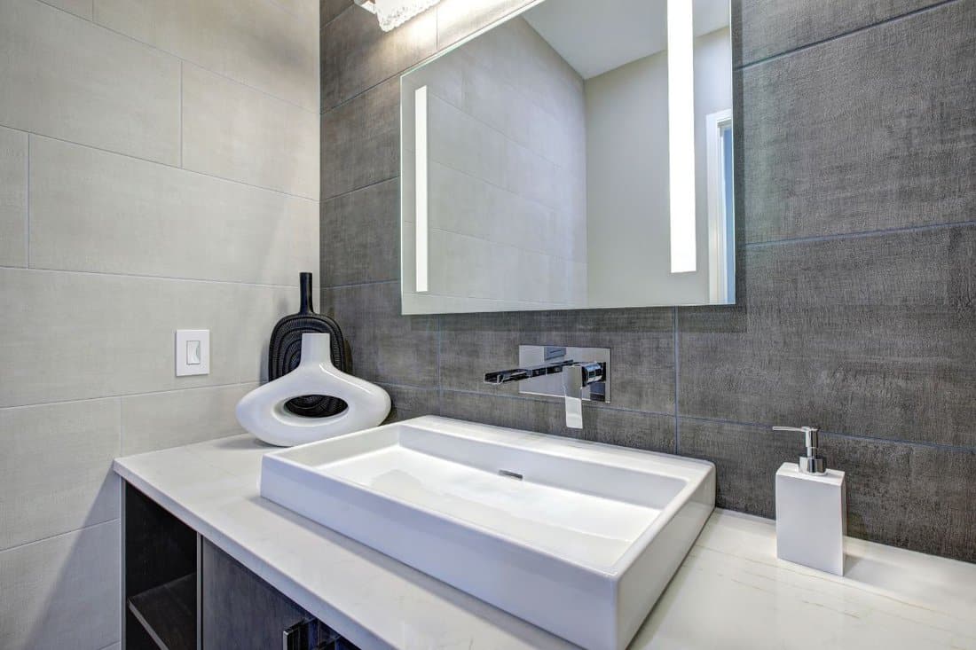 Contemporary bathroom interior with tile wall surround in gray tones