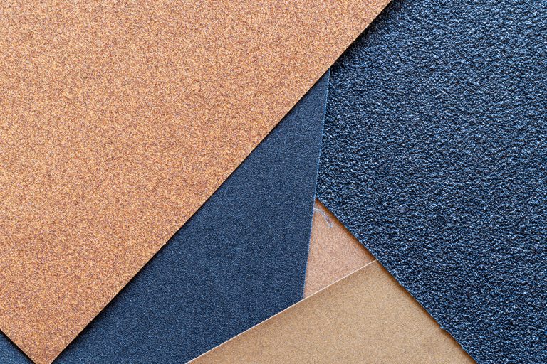 Different grains of sand on the surface of a sandpaper, What Grit Sandpaper Is For Cabinets?