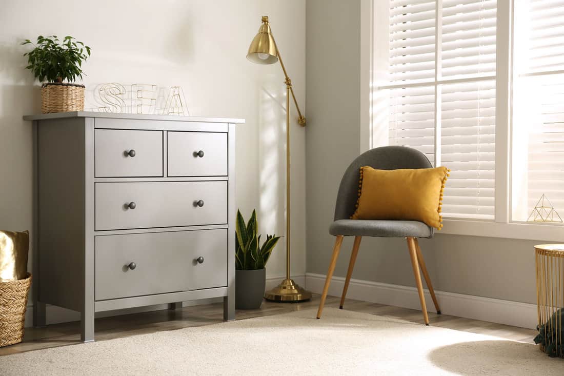 Grey chest of drawers in stylish room interior 