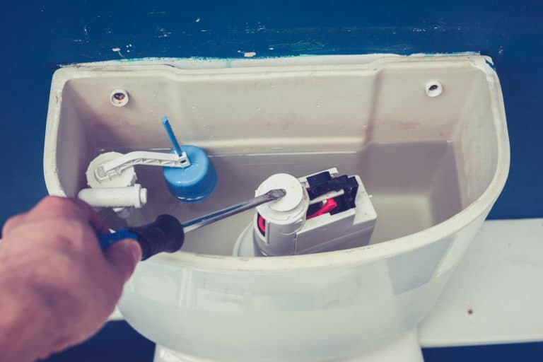 Hand is fixing a toilet cistern at home, How To Replace Kohler Flush Valve [Step By Step Guide]