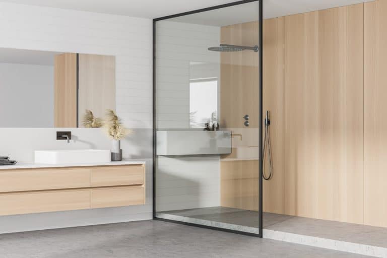 Interior of stylish bathroom with wooden walls, concrete floor, double sink with horizontal mirror and shower stall, Can You Cement Over A Fiberglass Shower?