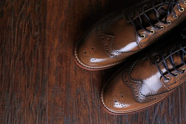 A pair of luxury brown shoes close up on wood background., Which One Is Better on Leather Shoes: Brush Paint Or Spray Paint?
