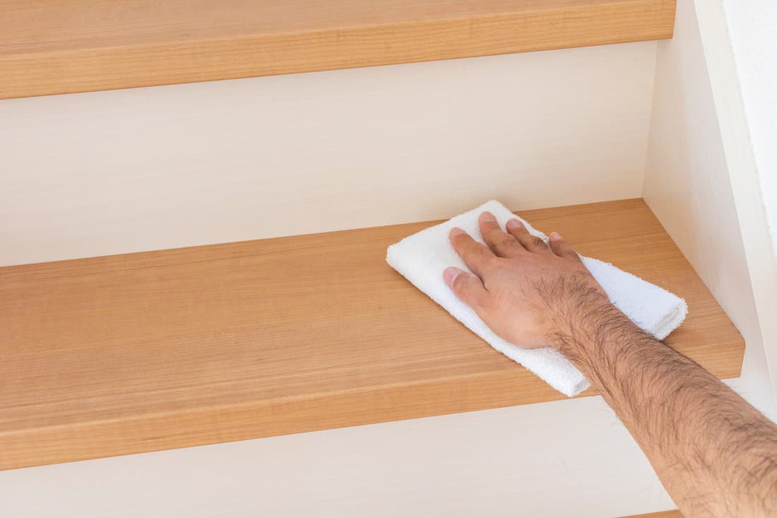 Man hand wiping stairs with towel