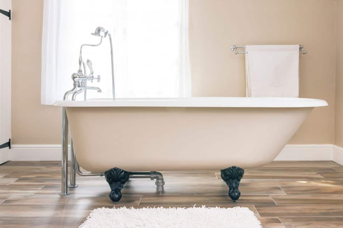 Modern bathroom interior design with clawfoot bath tub and floor tiles