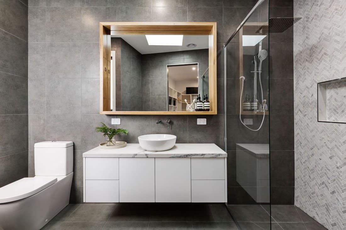 Modern grey designer bathroom with herringbone shower tiling.