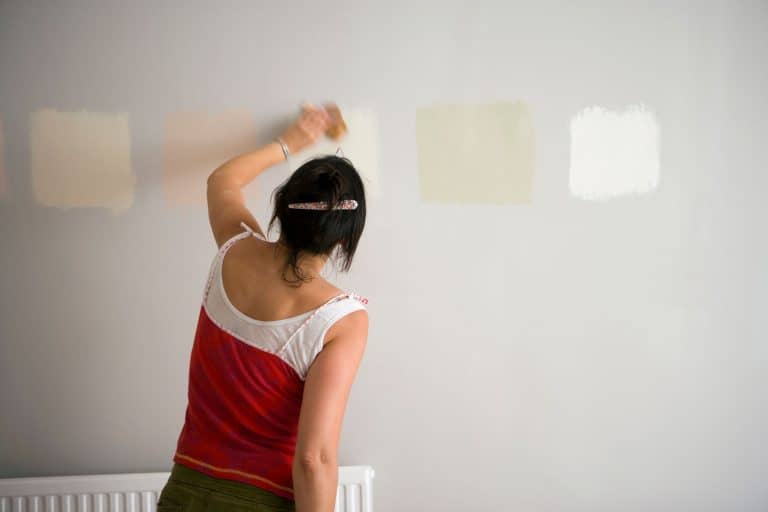 Rear view of a woman testing different paint shades over the wall, My Paint Doesn't Match The Sample - Why? What To Do?