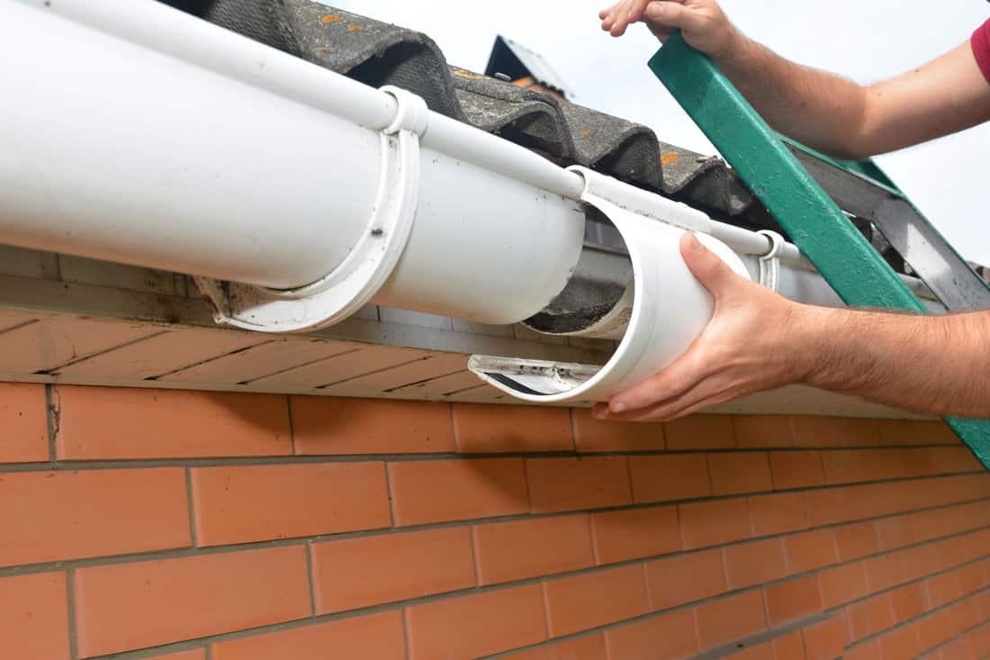 Roof gutter repair. Guttering repair. Roofer contractor repair house rain gutter pipeline. 